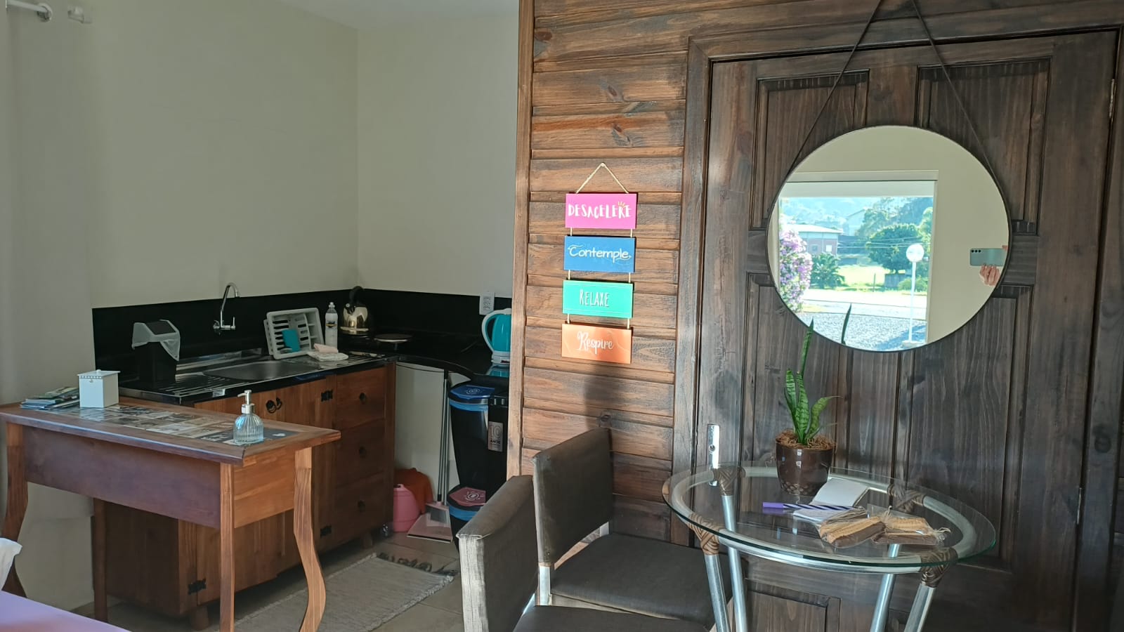 Sala da suíte com escrivaninha, espelho e área de estar
